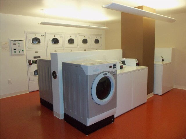 community laundry room featuring independent washer and dryer, stacked washing machine and dryer, and baseboards