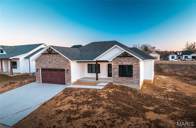 210 Sunny Dr, Rolla, MO 65401 - view of front of home featuring a porch, an attached garage, brick siding, concrete driveway, and board and batten siding