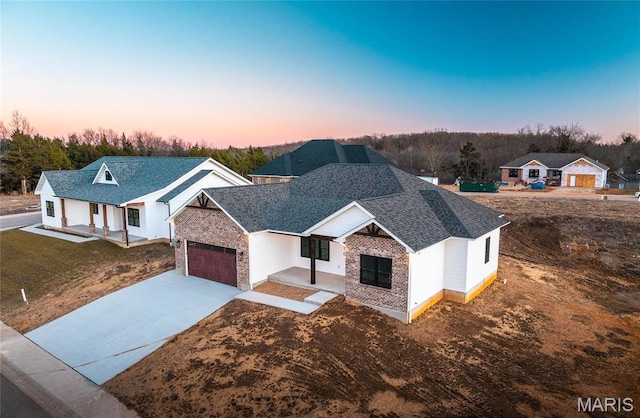 210 Sunny Dr, Rolla, MO 65401 - view of front of house with covered porch, driveway, roof with shingles, and an attached garage