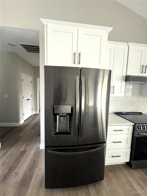 210 Sunny Dr, Rolla, MO 65401 - kitchen featuring stainless steel fridge with ice dispenser, electric stove, under cabinet range hood, dark wood-type flooring, and decorative backsplash