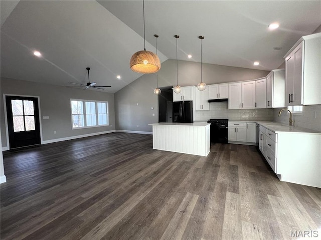 210 Sunny Dr, Rolla, MO 65401 - kitchen with black fridge, a sink, a ceiling fan, open floor plan, and a kitchen island