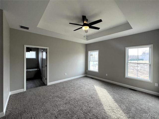 210 Sunny Dr, Rolla, MO 65401 - unfurnished bedroom with a raised ceiling, carpet floors, baseboards, ensuite bathroom, and a ceiling fan