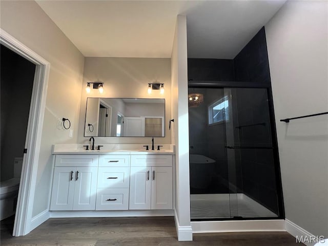 210 Sunny Dr, Rolla, MO 65401 - bathroom with toilet, a stall shower, wood finished floors, double vanity, and baseboards