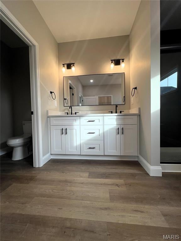 210 Sunny Dr, Rolla, MO 65401 - full bath featuring baseboards, double vanity, toilet, and wood finished floors