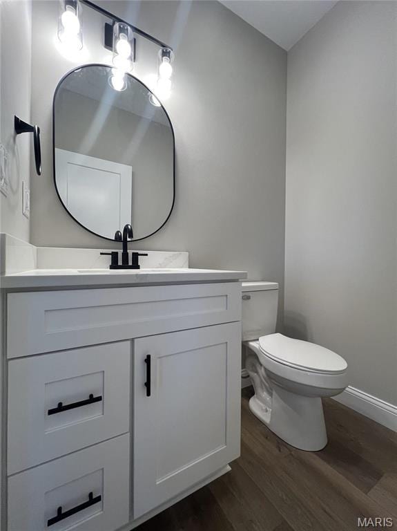 210 Sunny Dr, Rolla, MO 65401 - half bath featuring wood finished floors, vanity, toilet, and baseboards