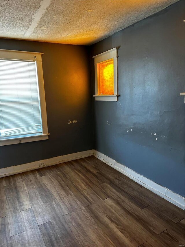 6705 Saint Louis Ave, Saint Louis, MO 63121 - unfurnished room with dark wood finished floors, baseboards, and a textured ceiling