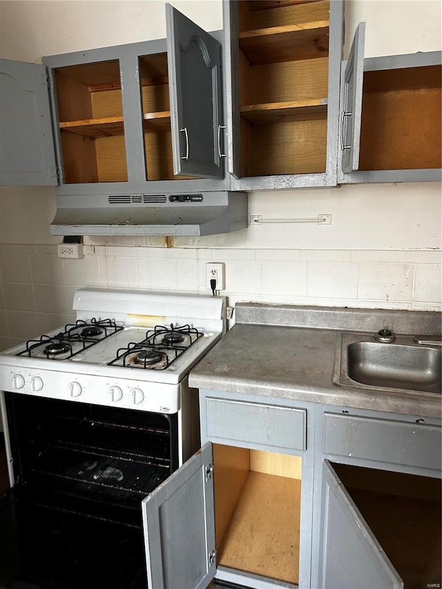 6705 Saint Louis Ave, Saint Louis, MO 63121 - kitchen featuring white range with gas stovetop, under cabinet range hood, open shelves, a sink, and decorative backsplash