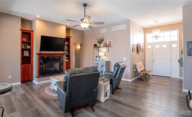 10415 Summerfield Dr, Rolla, MO 65401 - living area featuring a textured ceiling, wood finished floors, a high end fireplace, a chandelier, and baseboards