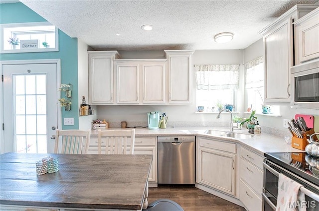 10415 Summerfield Dr, Rolla, MO 65401 - kitchen featuring stainless steel appliances, a sink, plenty of natural light, a textured ceiling, and dark wood finished floors
