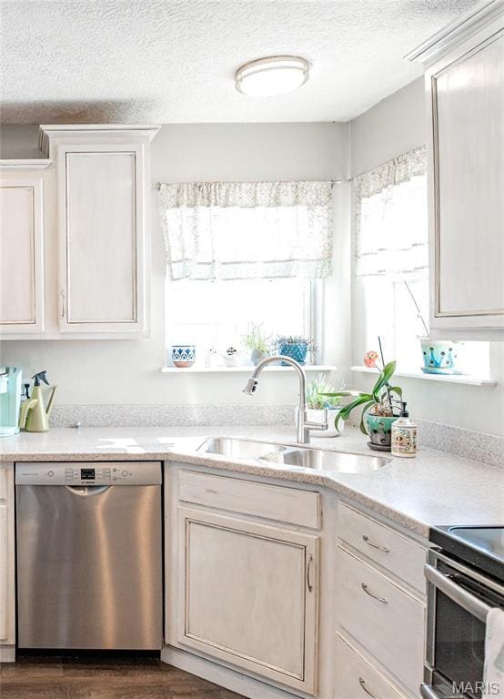 10415 Summerfield Dr, Rolla, MO 65401 - kitchen with appliances with stainless steel finishes, a sink, a textured ceiling, light countertops, and dark wood-style flooring