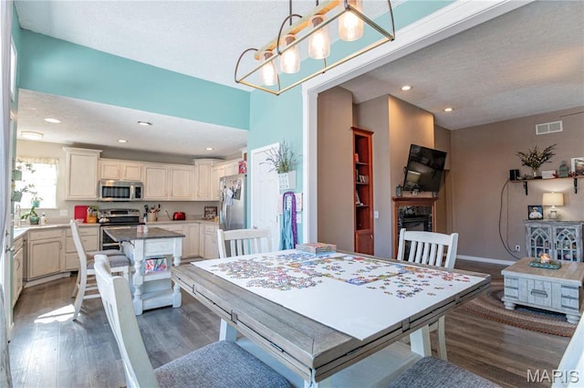 10415 Summerfield Dr, Rolla, MO 65401 - dining area featuring dark wood finished floors, a textured ceiling, a premium fireplace, recessed lighting, and baseboards