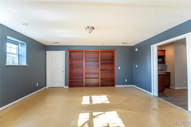10415 Summerfield Dr, Rolla, MO 65401 - unfurnished bedroom with finished concrete flooring, a textured ceiling, and baseboards