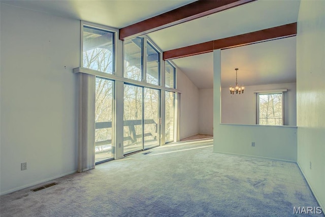 empty room featuring a chandelier, carpet floors, and baseboards
