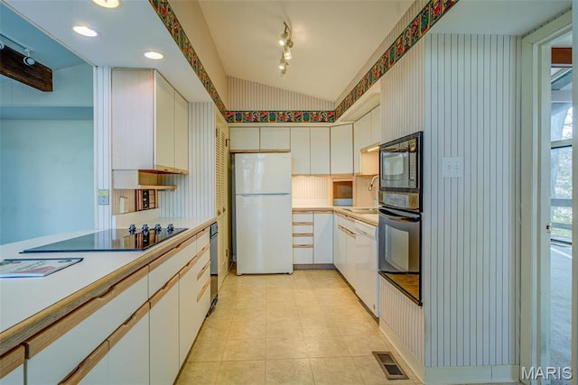 kitchen featuring black appliances, light countertops, vaulted ceiling, white cabinets, and a sink