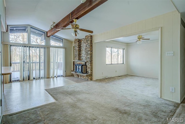 unfurnished living room featuring a ceiling fan, a stone fireplace, and carpet