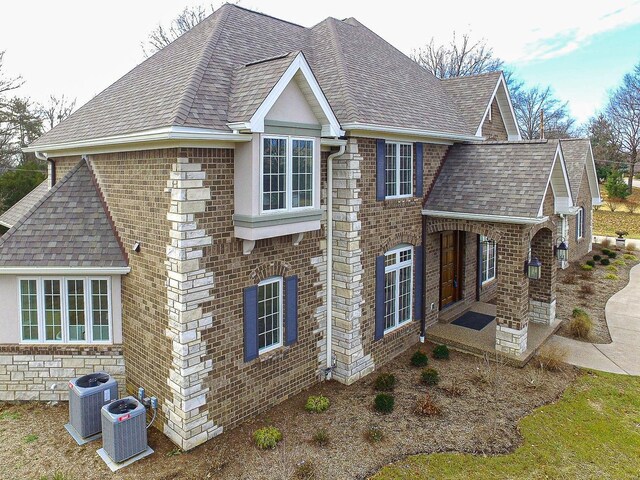 267 Saint Andrews Dr, Saint Albans, MO 63073 - view of property exterior featuring a shingled roof, cooling unit, brick siding, and a patio