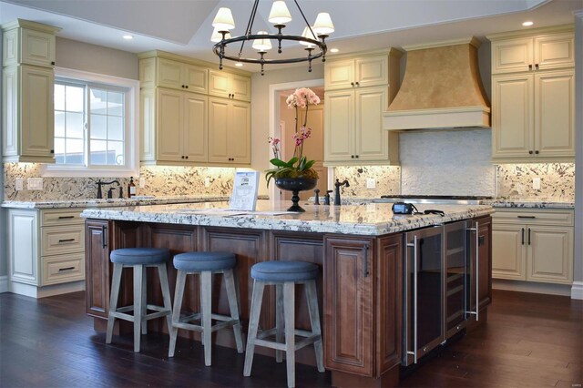 267 Saint Andrews Dr, Saint Albans, MO 63073 - kitchen with custom range hood, beverage cooler, a chandelier, a center island, and light stone counters
