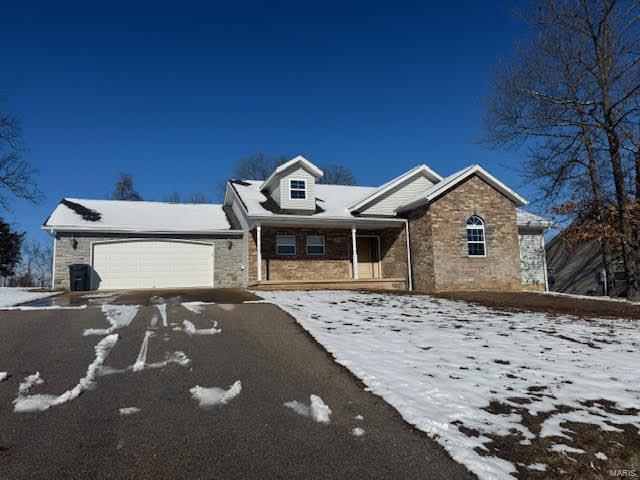 18882 Ladera Rd, Waynesville, MO 65583 - view of front of property with an attached garage, brick siding, a porch, and asphalt driveway