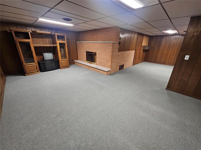 111 Linn Dr, Saint Genevieve, MO 63670 - finished below grade area with wood walls, a drop ceiling, a brick fireplace, and carpet