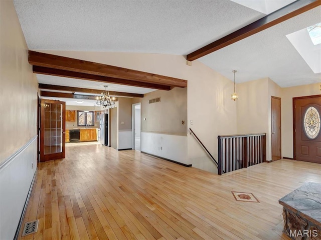 3553 Evergreen Dr, Catawissa, MO 63015 - unfurnished living room with a chandelier, a skylight, light wood-style floors, and a textured ceiling