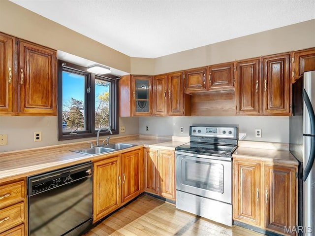 3553 Evergreen Dr, Catawissa, MO 63015 - kitchen with appliances with stainless steel finishes, a sink, light countertops, light wood-style floors, and brown cabinets