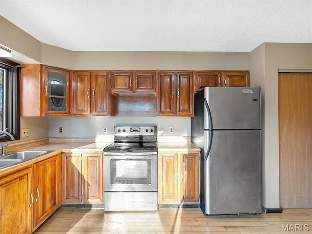 3553 Evergreen Dr, Catawissa, MO 63015 - kitchen with appliances with stainless steel finishes, a sink, light countertops, brown cabinetry, and a textured ceiling