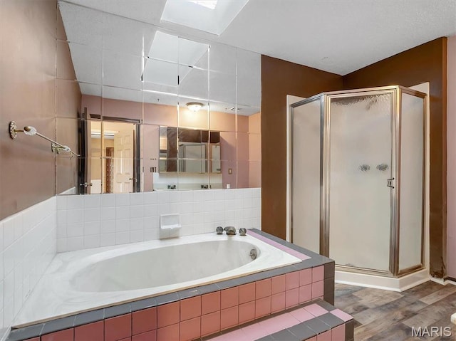 3553 Evergreen Dr, Catawissa, MO 63015 - bathroom featuring a shower stall, a bath, wood finished floors, and a skylight