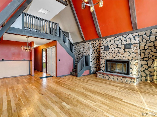 3553 Evergreen Dr, Catawissa, MO 63015 - unfurnished living room featuring a high ceiling, a chandelier, stairway, hardwood / wood-style flooring, and a fireplace