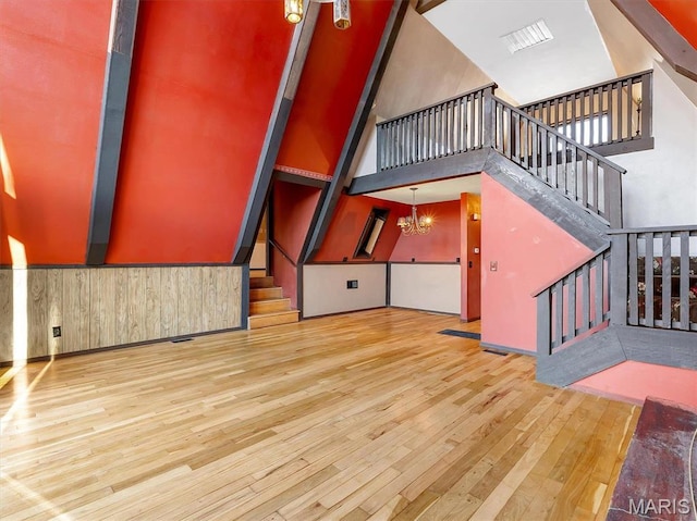 3553 Evergreen Dr, Catawissa, MO 63015 - unfurnished living room featuring a high ceiling, stairs, wood finished floors, and a chandelier