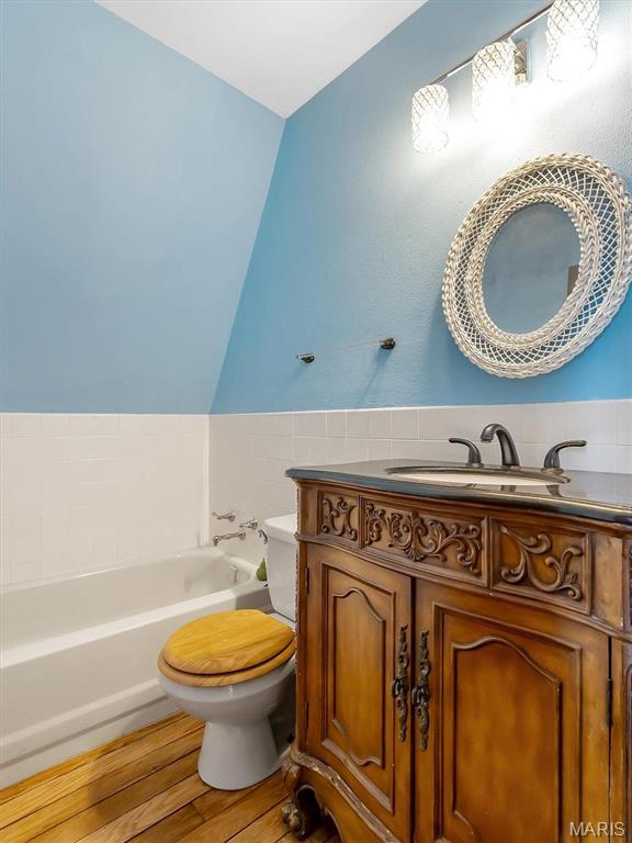 3553 Evergreen Dr, Catawissa, MO 63015 - bathroom with a garden tub, toilet, wood finished floors, vanity, and lofted ceiling