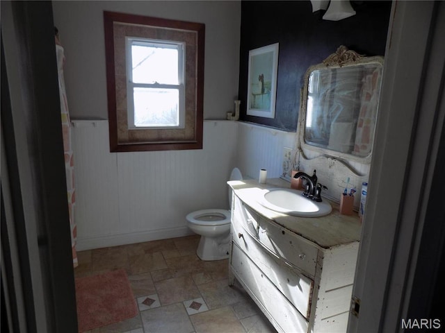 170 County Rd, Ironton, MO 63650 - bathroom with a wainscoted wall, vanity, toilet, stone finish floors, and baseboards