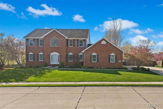 colonial inspired home featuring brick siding