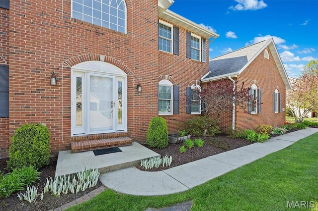 doorway to property featuring brick siding