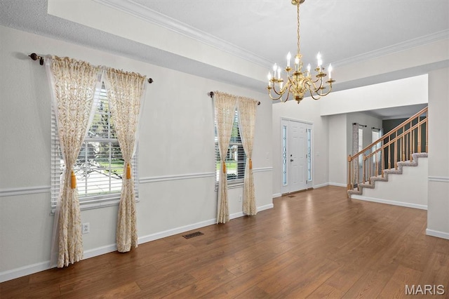 entryway with a chandelier, ornamental molding, wood finished floors, stairway, and baseboards