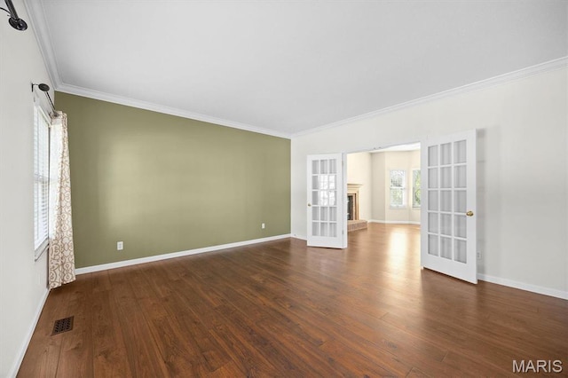 unfurnished room featuring french doors, ornamental molding, wood finished floors, and baseboards