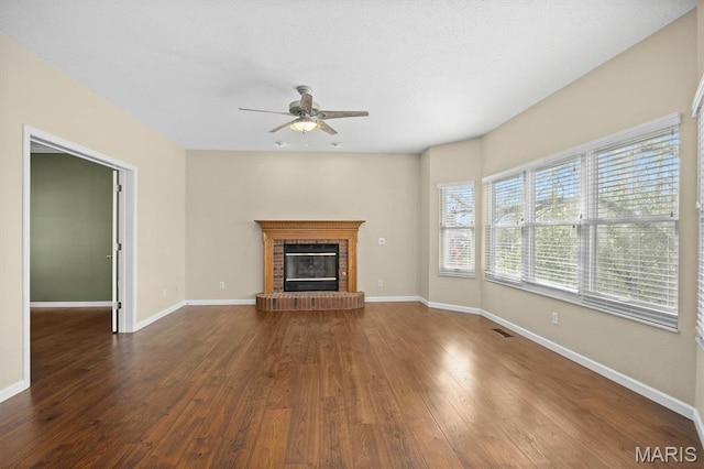 unfurnished living room with a ceiling fan, wood-type flooring, baseboards, and a fireplace