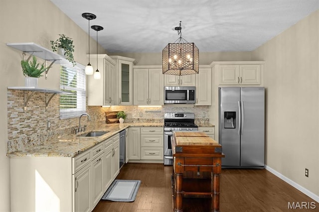 kitchen with stainless steel appliances, a sink, open shelves, light stone counters, and dark wood finished floors