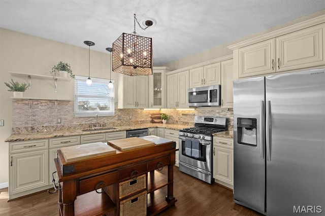 kitchen featuring stainless steel appliances, a sink, dark wood-style flooring, and light stone counters
