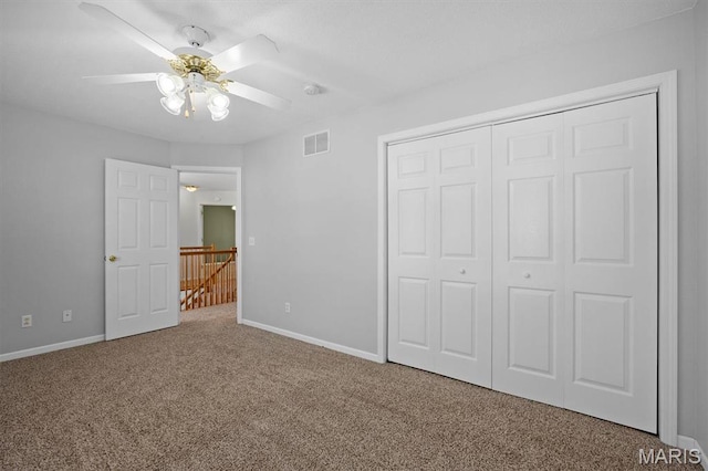 unfurnished bedroom featuring carpet, a closet, baseboards, and ceiling fan