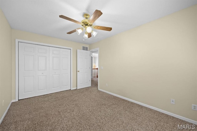 unfurnished bedroom with carpet floors, baseboards, a closet, and a ceiling fan