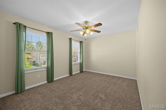 empty room featuring carpet flooring, a ceiling fan, and baseboards