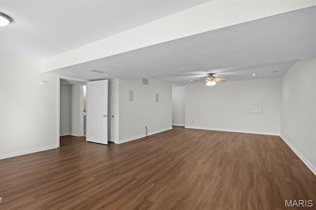 unfurnished living room with dark wood-style flooring, baseboards, and ceiling fan