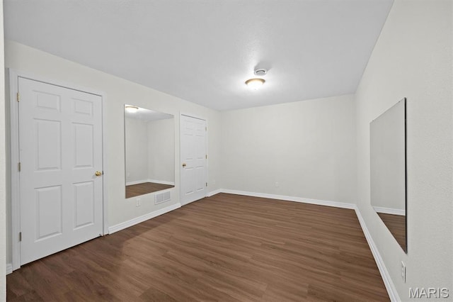 empty room featuring wood finished floors and baseboards