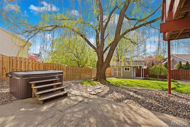 view of patio with a hot tub, a shed, and an outdoor structure