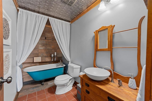 bathroom with an ornate ceiling, toilet, tile patterned flooring, and vanity
