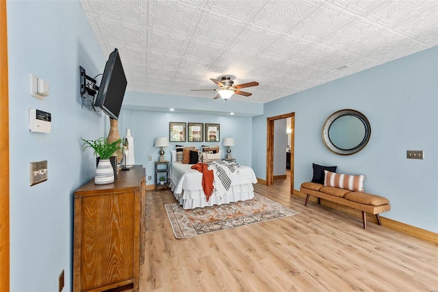 bedroom with wood finished floors, baseboards, an ornate ceiling, and a ceiling fan