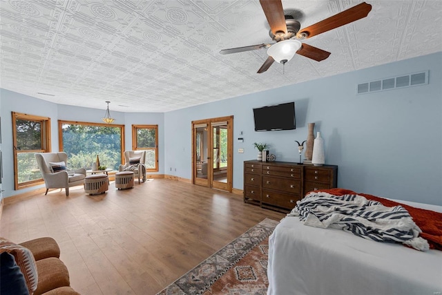 bedroom with wood finished floors, an ornate ceiling, baseboards, a ceiling fan, and access to outside
