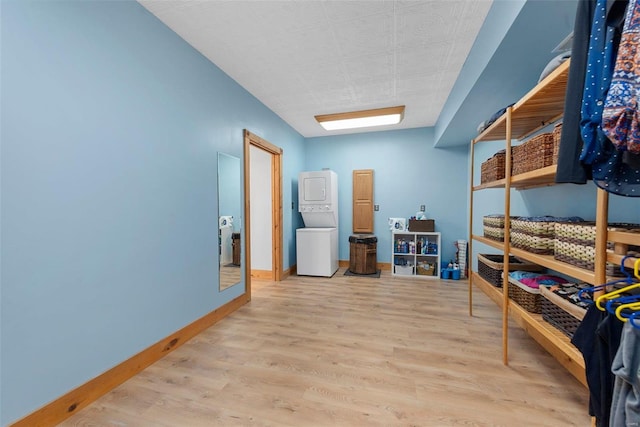 storage room with stacked washer and clothes dryer