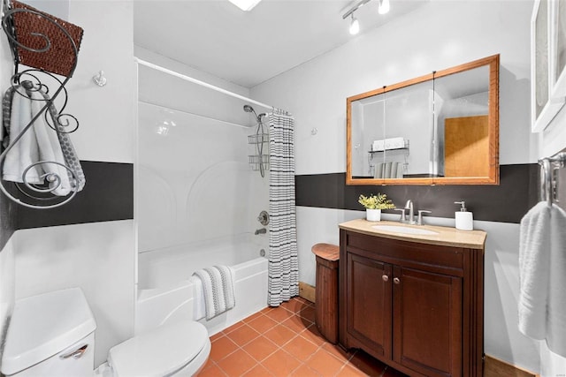 bathroom featuring toilet, shower / bath combo with shower curtain, tile patterned floors, and vanity