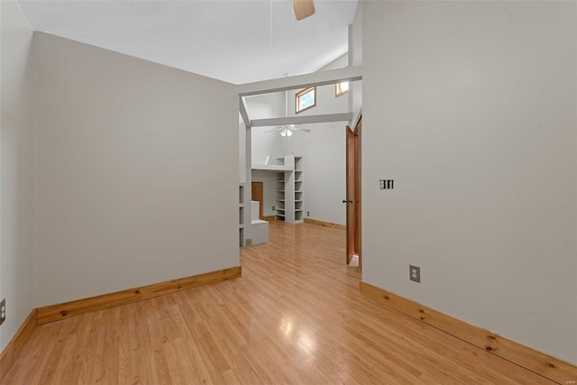 spare room with ceiling fan, baseboards, light wood-style floors, and built in shelves